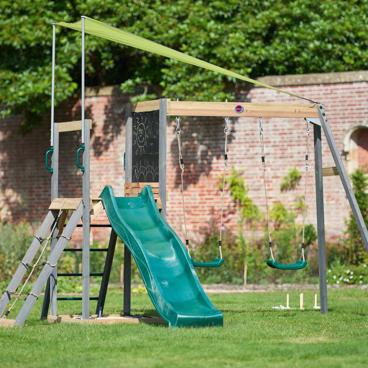 Right angle view of Plum Play's Siamang Wooden Playcentre Climbing Frame installed in a backyard lawn