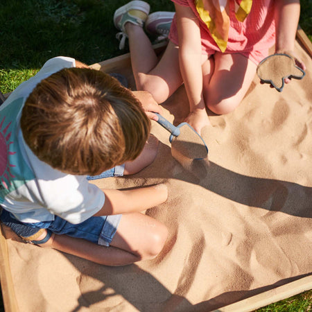 Two children playing in the sand pit of Plum Play's Siamang Wooden Playcentre Climbing Frame