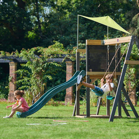 Children sliding and swinging in the Plum Play's Siamang Wooden Playcentre Climbing Frame