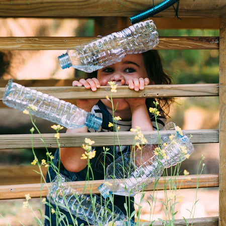 Child peeking through the wood trellis of Plum Discovery Woodland Treehouse