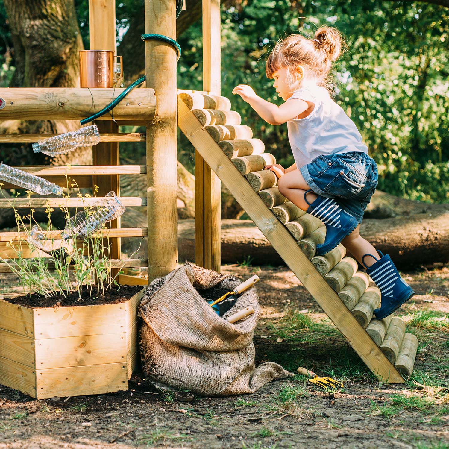 A child climbing the Plum Discovery Woodland Treehouse