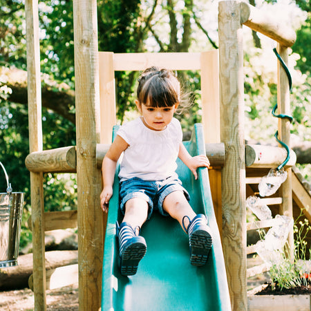 Little girl sliding in Plum Discovery Woodland Treehouse