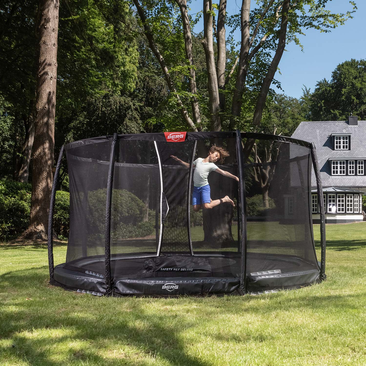 a child jumping in the BERG Elite InGround Round Trampoline with Safety Net Deluxe