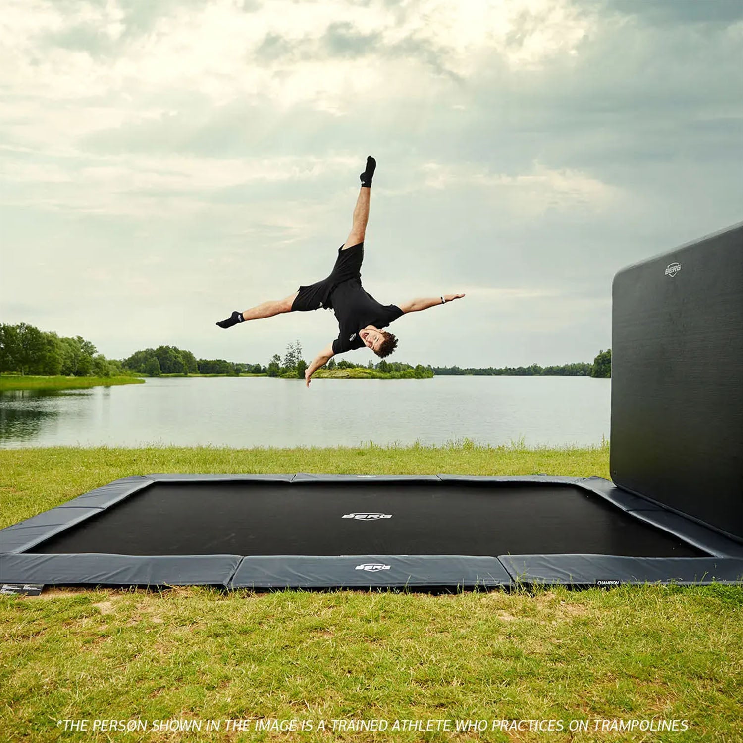 a trained athlete having fun jumping on a BERG SPORTS Ultim Champion FlatGround Rectangular Trampoline with AeroWall