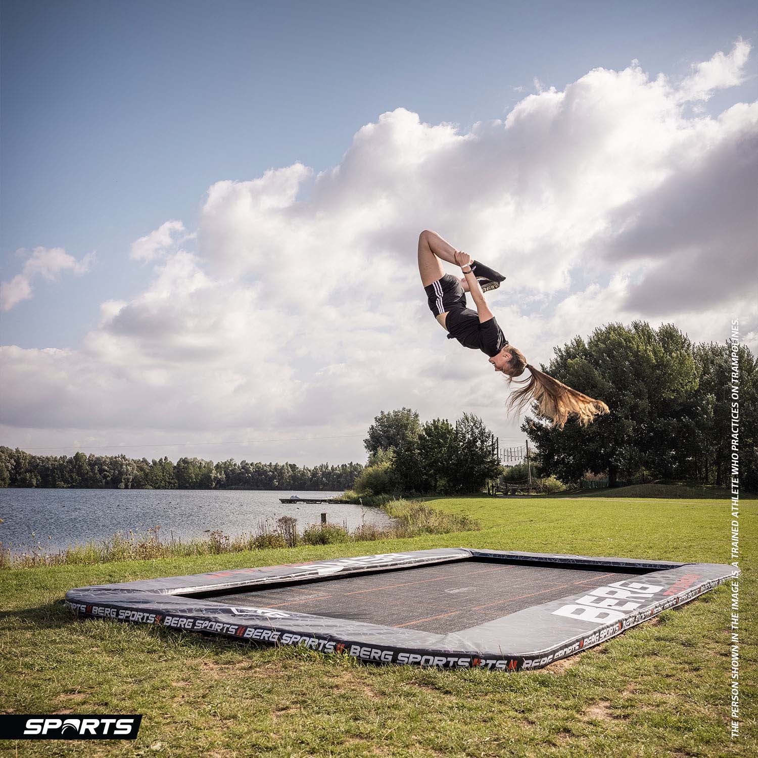 a trained female athlete performing acrobatic exercise on a BERG SPORTS Ultim Pro Bouncer FlatGround Rectangular Trampoline